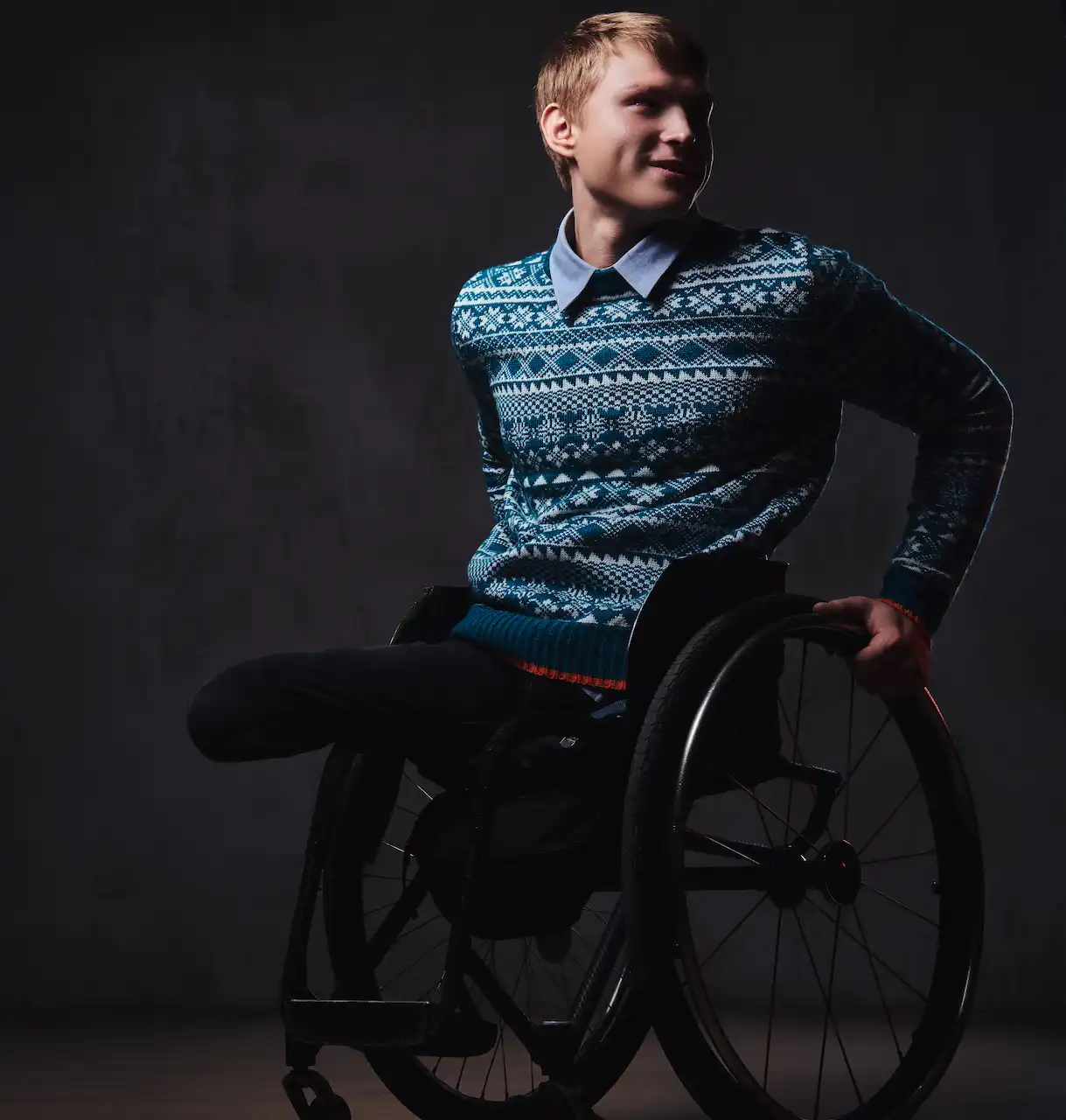 A man in a wheelchair wearing fashionable clothing.